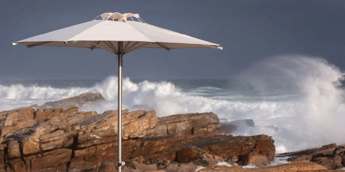 Stainless steel market umbrella with white octagonal canopy on the coast